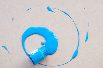 Directly above shot of blue paint spilled on table