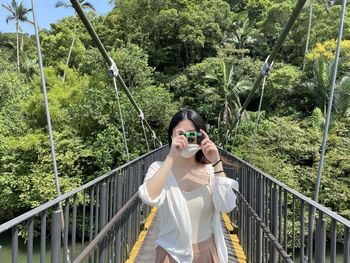 Girl holding camera on a drawbridge 