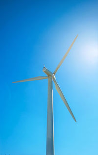 Big white propeller of wind power plant on blue sky background