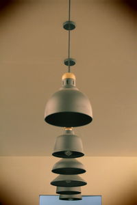 Low angle view of illuminated pendant light on wall at home