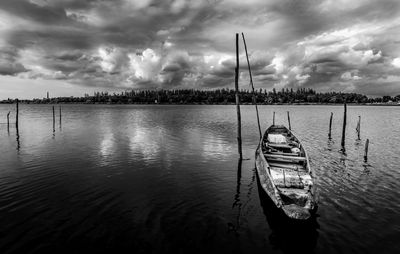Fishing boat in lake against sky