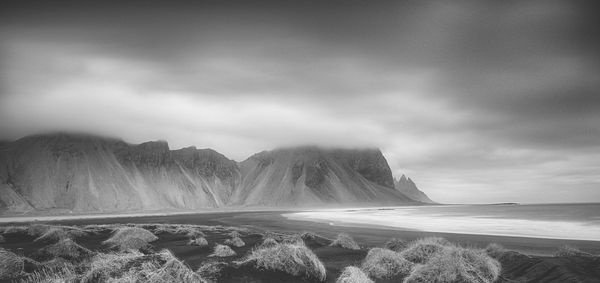 Scenic view of sea and mountains against sky