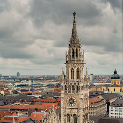 Buildings in city against cloudy sky