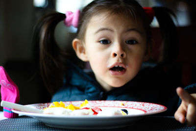 Close-up portrait of cute girl eating food