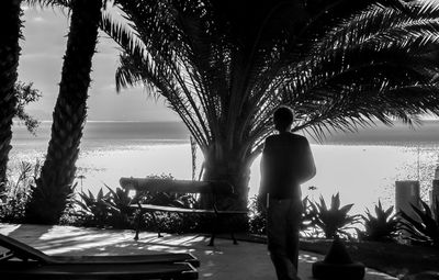 Woman standing by swimming pool against sky