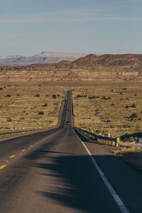 Road leading towards mountain against sky