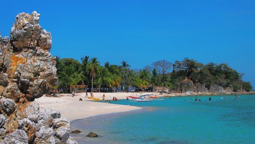 Scenic view of beach against clear blue sky