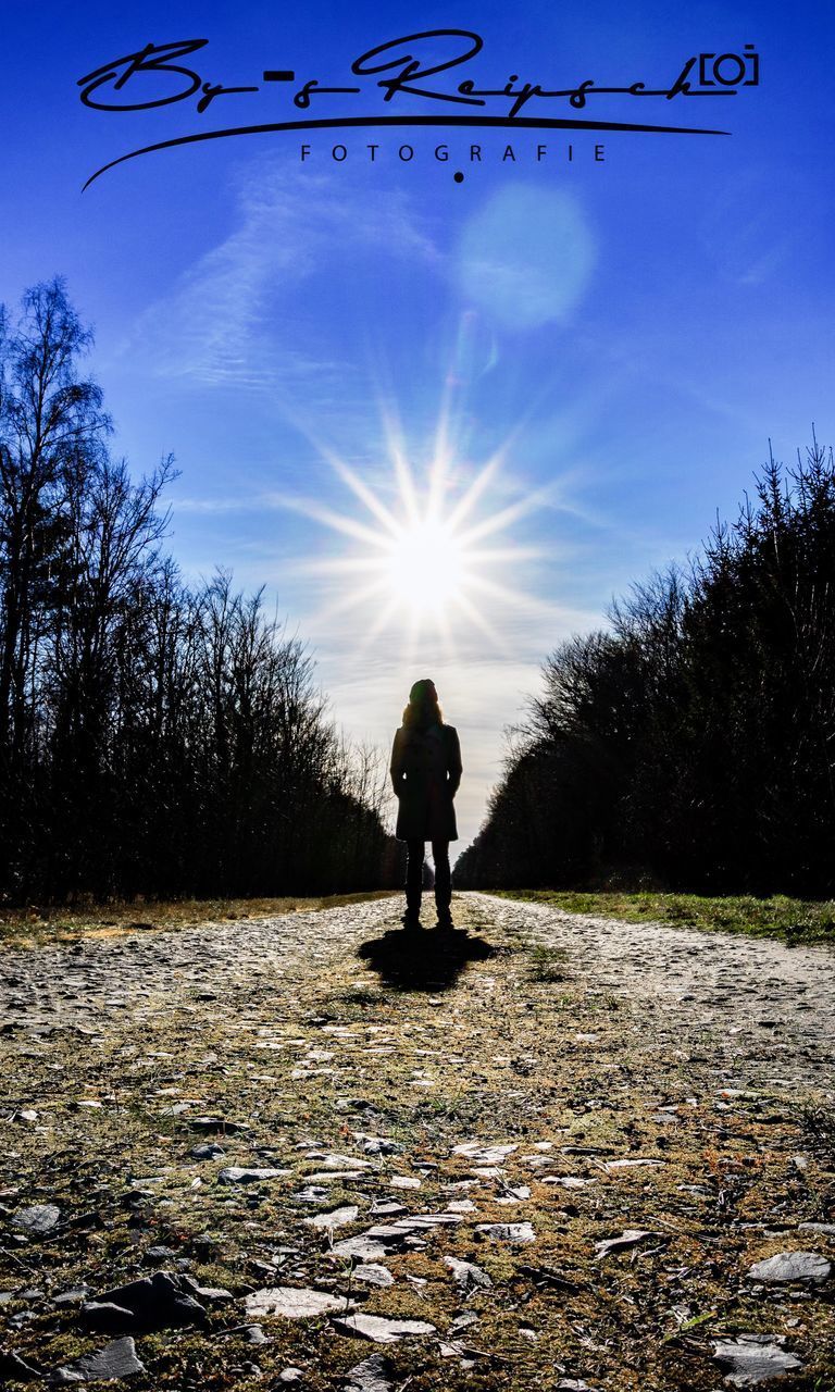 MAN STANDING ON FIELD AGAINST SKY