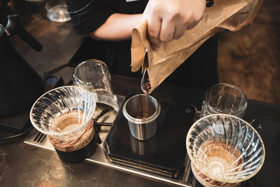 High angle view of hand pouring wine in glass