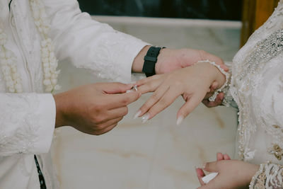 Midsection of bride holding wedding dress