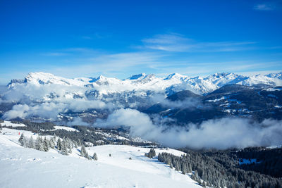 Scenic view of snowcapped mountains against blue sky