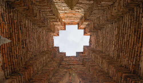 Low angle view of brick wall against sky