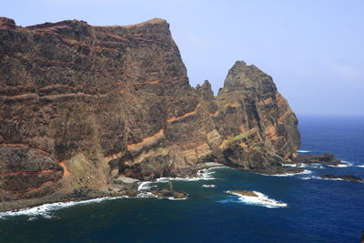 Rock formations by sea against sky