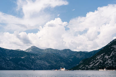 Scenic view of sea and mountains against sky