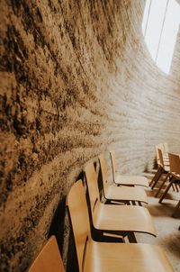 High angle view of empty chairs and table against wall