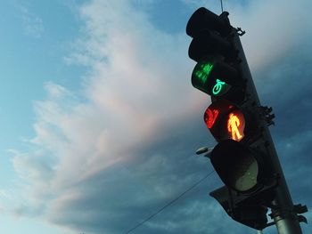 Low angle view of road signal against cloudy sky at dusk