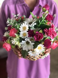 Midsection of woman holding flower bouquet