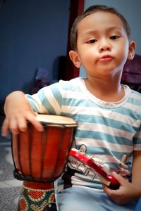 Portrait of cute boy playing a little bongo