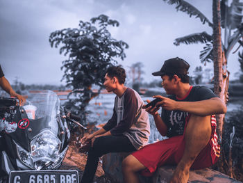 People sitting in park against sky