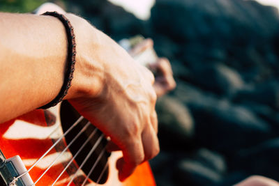 Close-up of person playing guitar