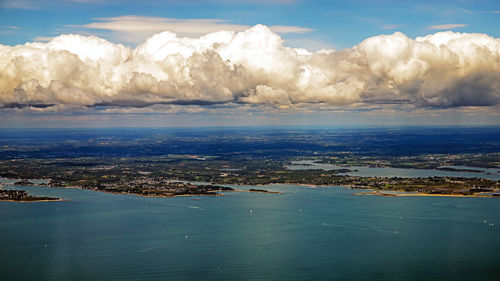 Aerial view of sea and cityscape against sky