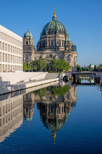 The berlin cathedral with the reconstructed city palace reflected in the river spree