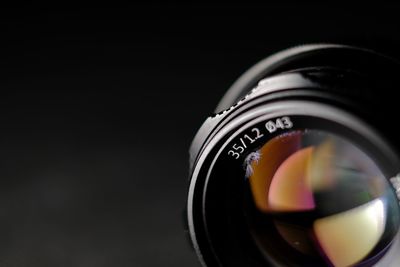 Close-up of camera lens against black background