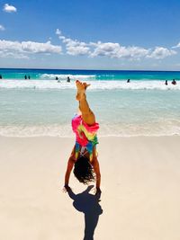 Full length of woman on beach against sky