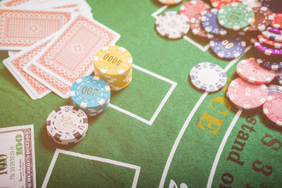 High angle view of gambling chips and cards on blackjack table