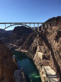 Arch bridge over river against sky