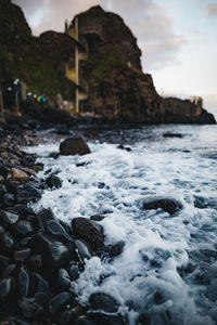 Surface level of rocks on beach against sky