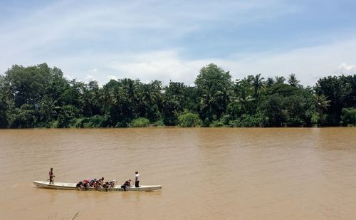 People enjoying in river against sky