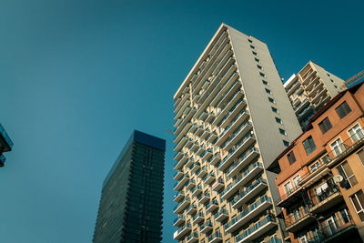 Low angle view of modern buildings against clear blue sky