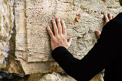 Midsection of man touching wall