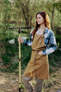 Portrait of young woman standing on field