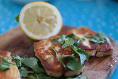 Close-up of halloumi with lemon on cutting board