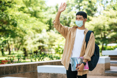 Portrait of young man standing against wall