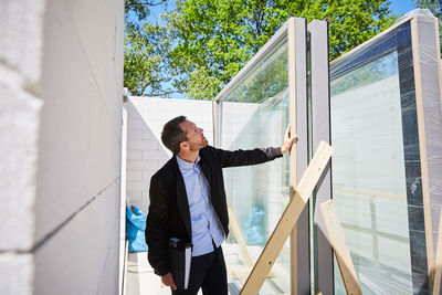 Architect with file analyzing at construction site on sunny day