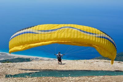 Boy with parachute against sea