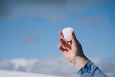 Close-up of person hand against sky