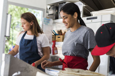 Confident multi-ethnic female colleagues working in food truck