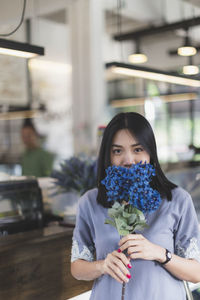 Portrait of a beautiful young woman holding flower