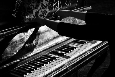 Close-up of hand playing piano