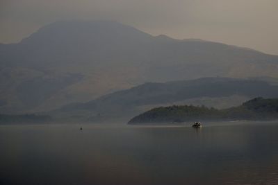 Scenic view of sea and mountains against sky