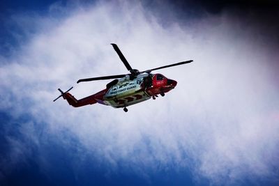 Low angle view of helicopter flying against sky