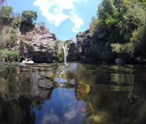 Scenic view of rock formation by river against sky