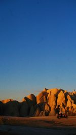 Rock formations against clear blue sky