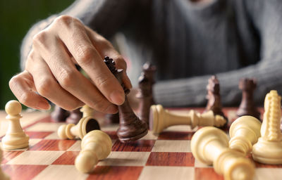 Close-up of hand holding chess pieces