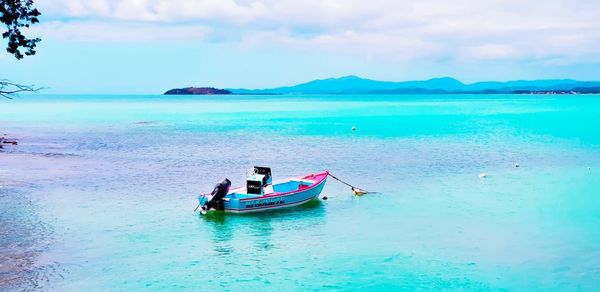 People on boat in sea against sky