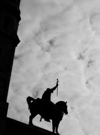 Low angle view of silhouette statue at basilique du sacre coeur against cloudy sky